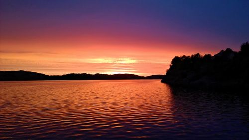 Scenic view of sea against dramatic sky during sunset