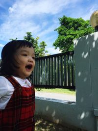 Girl looking at camera against sky