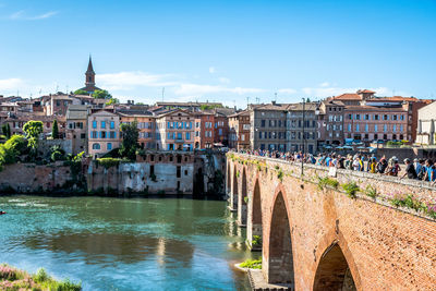 Bridge over river against buildings in city