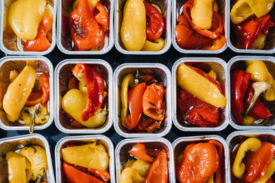 Pre-portioned gourmet roasted bell peppers in trays. close-up view of vibrant roasted bell 