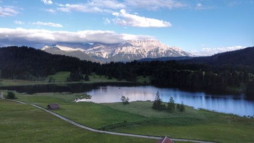 Scenic view of lake by mountains against sky