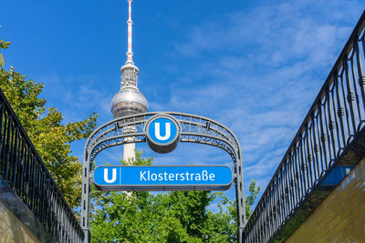 Low angle view of information sign against blue sky