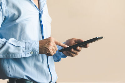 Midsection of man using mobile phone