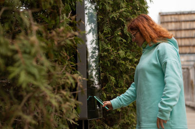 Rear view of woman standing against plants