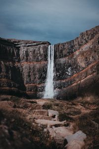 Scenic view of waterfall against sky