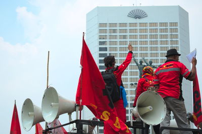 People in front of building against sky