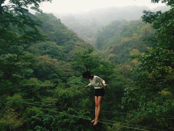 Man standing on tree in forest