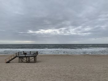 Lifeguard hut on beach against sky