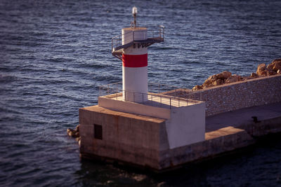 Tilt shift effect of fisherman on large rocky boulders of the pier of the port of athens, greece