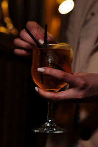 Midsection of woman holding wineglass