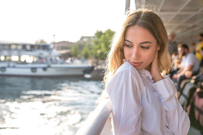 Thoughtful young woman standing on boat in river