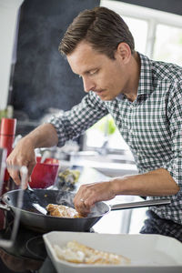 Man preparing fish in kitchen