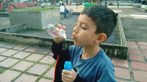 Close-up of boy holding bubbles in water