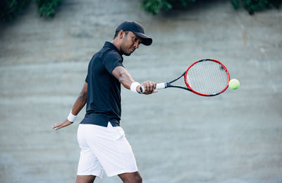 Midsection of man playing tennis