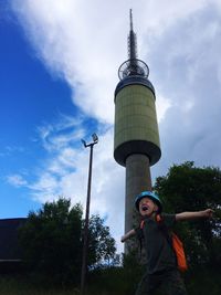 Low angle view of boy standing against tower