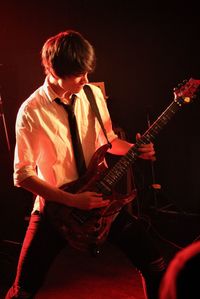 Full length of young man playing electric guitar