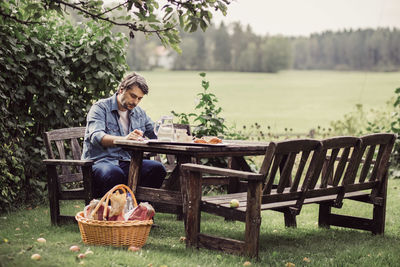 Mid adult man having breakfast at table in organic farm