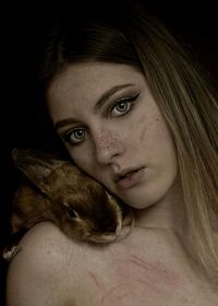 Close-up portrait of young woman with rabbit