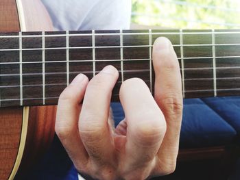 Midsection of man playing guitar