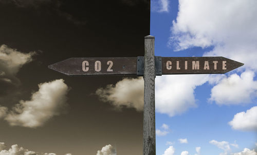Low angle view of information sign against sky