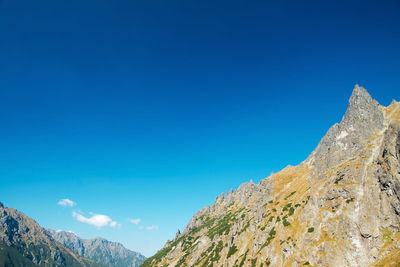 Low angle view of mountain against blue sky