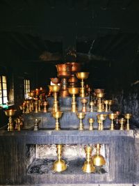 Illuminated light bulbs hanging on table by building