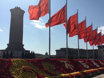 Red flags on flowers against sky