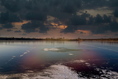 Scenic view of lake against sky at sunset