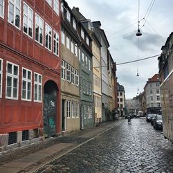 Buildings in city against cloudy sky