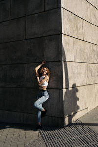 Portrait of woman standing against brick wall