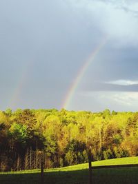 Scenic view of rainbow over landscape against sky