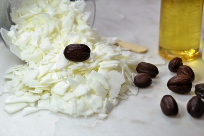 Close-up of jojoba seeds with oil and flakes on table