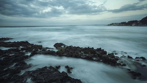 Scenic view of sea against cloudy sky