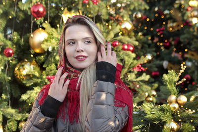 Portrait of young woman with christmas tree