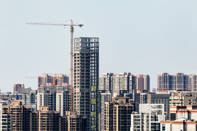 Construction site in city against clear sky