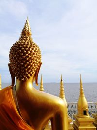 Close-up of buddha statue against sky