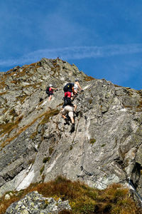 Full length of people climbing rocks in a mountain at heini-holzer-klettersteig, meran 2000