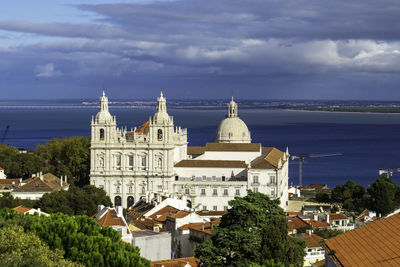 High angle view of two churches in front of the tejo river against cloudy sky