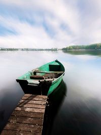 Boat moored in lake against sky