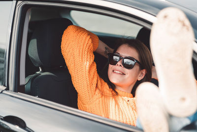 Portrait of young woman sitting in car