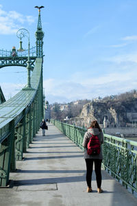 Rear view of people walking on footbridge