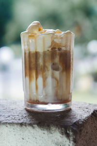 A glass of affogato beverage. a shot of espresso with vanilla ice cream