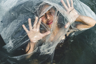 High angle view of girl amidst plastic in sea