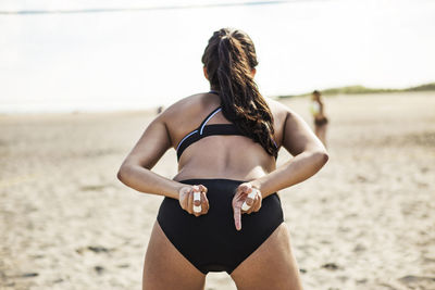 Rear view of woman standing at beach