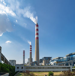 Low angle view of smoke emitting from factory against sky