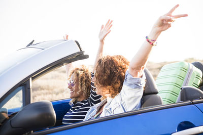 Carefree female friends enjoying in car