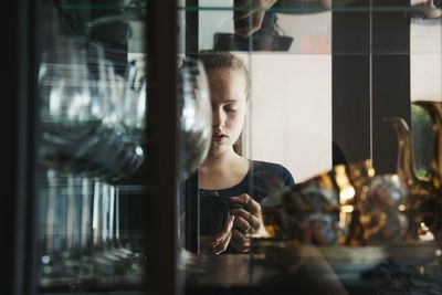 Woman with camera standing at home