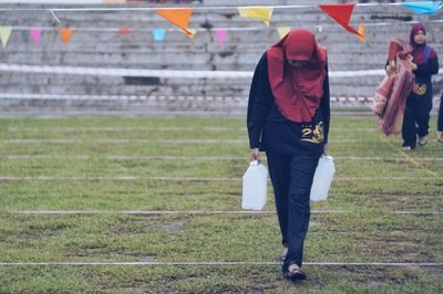 Rear view of a woman walking on grassland