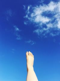 Low section of woman against blue sky