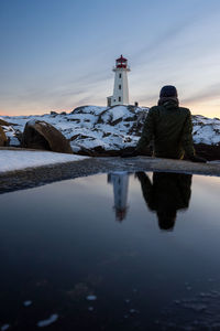 Reflection of lighthouse in sea against sky during sunset, peggy's cove, ns, canada